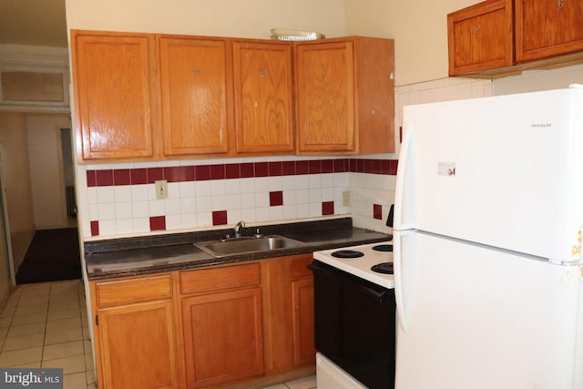 1501 Druid Hill Ave, Baltimore, MD 21217 - kitchen featuring freestanding refrigerator, a sink, electric range, tasteful backsplash, and brown cabinetry