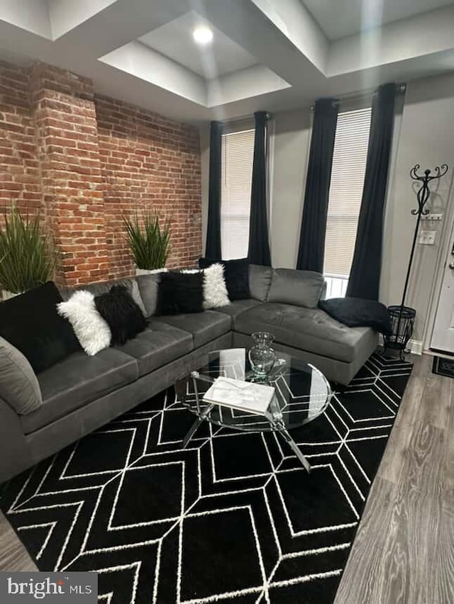 1528 N Ellamont St, Baltimore, MD 21216 - living area featuring brick wall, a raised ceiling, healthy amount of natural light, and wood finished floors
