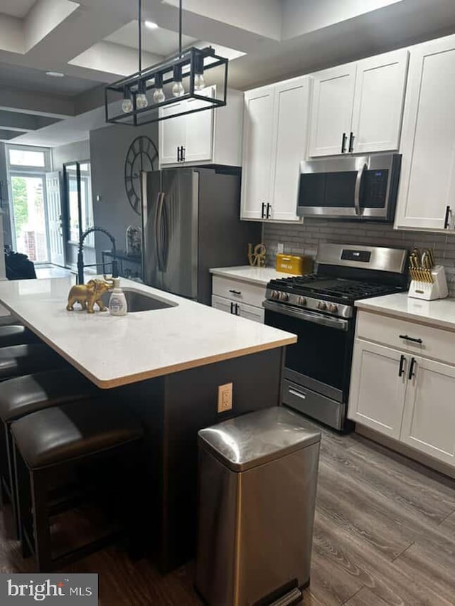 1528 N Ellamont St, Baltimore, MD 21216 - kitchen with stainless steel appliances, a sink, a kitchen island with sink, dark wood finished floors, and coffered ceiling