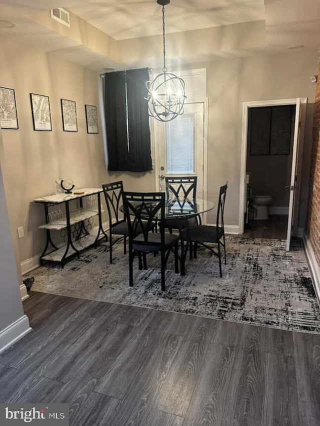 1528 N Ellamont St, Baltimore, MD 21216 - dining area featuring a chandelier, baseboards, and wood finished floors