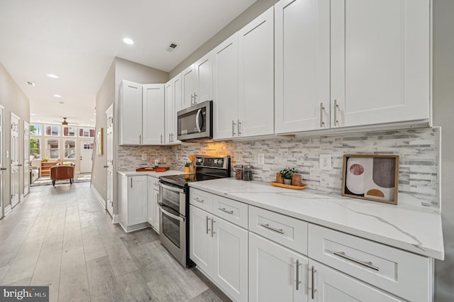 518 N Patterson Park Ave, Baltimore, MD 21205 - kitchen featuring appliances with stainless steel finishes, backsplash, light stone counters, white cabinetry, and recessed lighting