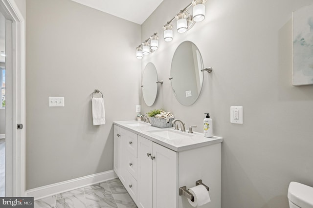 518 N Patterson Park Ave, Baltimore, MD 21205 - bathroom featuring marble finish floors, toilet, double vanity, and baseboards