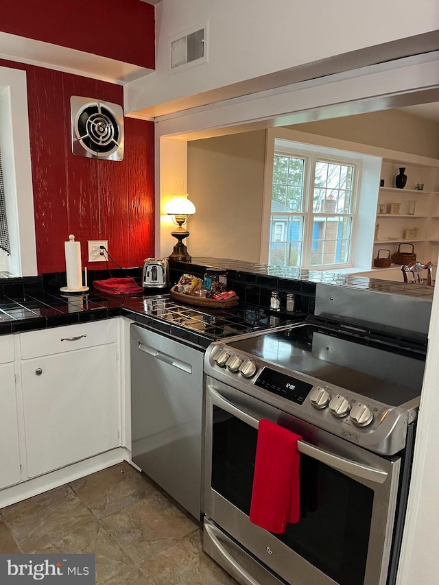 896 Hershey Heights Rd, Hanover, PA 17331 - kitchen with stainless steel appliances, white cabinetry, tile countertops, and stone finish floors