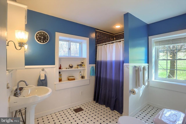 896 Hershey Heights Rd, Hanover, PA 17331 - bathroom with healthy amount of natural light, a shower with curtain, toilet, a wainscoted wall, and a sink