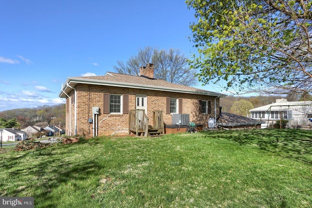 896 Hershey Heights Rd, Hanover, PA 17331 - rear view of property featuring a lawn, a chimney, brick siding, and central AC
