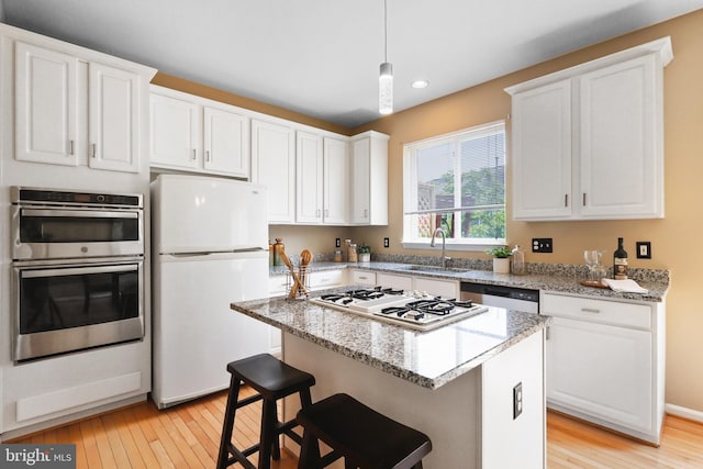 13619 Red Squirrel Way, Herndon, VA 20171 - kitchen with appliances with stainless steel finishes, light wood finished floors, white cabinets, recessed lighting, and a center island