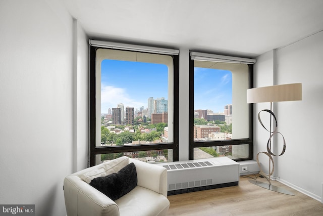 210 Locust St Unit 19Gw, Philadelphia, PA 19106 - living area featuring a view of skyline, wood finished floors, radiator heating unit, and floor to ceiling windows
