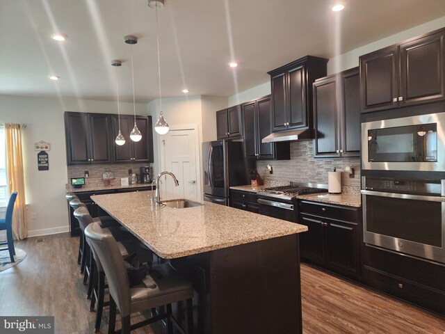 114 Furies St, Smyrna, DE 19977 - kitchen featuring stainless steel appliances, a sink, a center island with sink, light stone counters, and tasteful backsplash