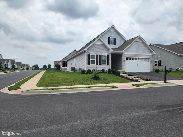 114 Furies St, Smyrna, DE 19977 - view of front of home featuring asphalt driveway, a front lawn, cooling unit, and an attached garage