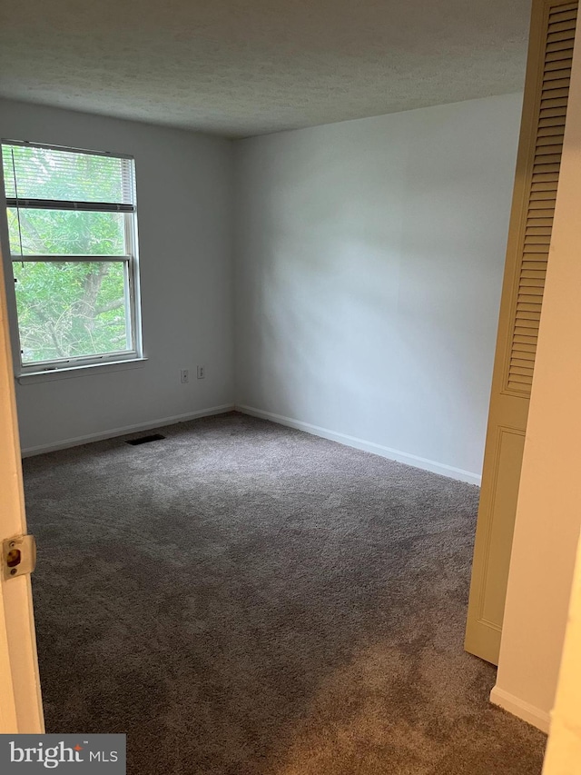 7539 Rain Flower Way, Columbia, MD 21046 - spare room featuring dark carpet and a textured ceiling