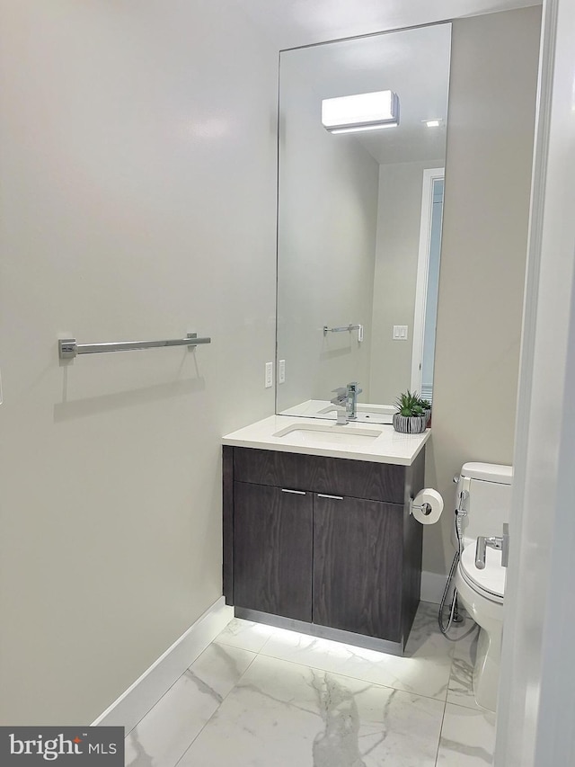 1753 Willard St NW Unit 3, Washington, DC 20009 - half bathroom featuring baseboards, toilet, vanity, and marble finish flooring