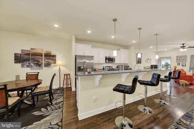 8346 Daydream Cres, Pasadena, MD 21122 - kitchen with appliances with stainless steel finishes, dark wood-style flooring, a breakfast bar, baseboards, and recessed lighting
