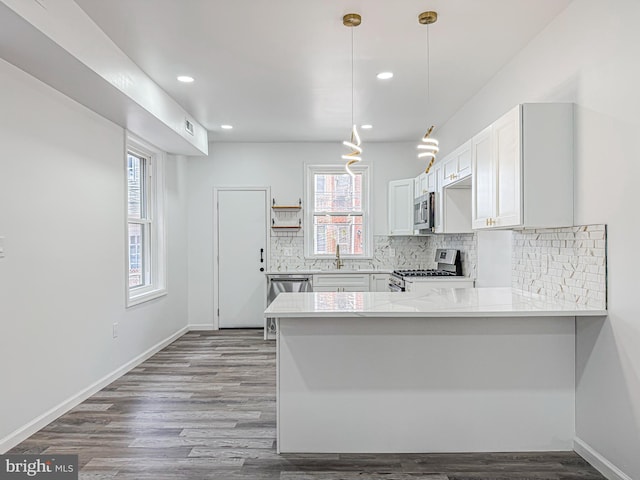 5849 Washington Ave, Philadelphia, PA 19143 - kitchen with stainless steel appliances, plenty of natural light, a peninsula, light countertops, and recessed lighting