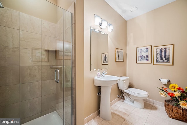 901 N Penn St Unit F2003, Philadelphia, PA 19123 - bathroom featuring toilet, tile patterned flooring, a stall shower, baseboards, and a sink