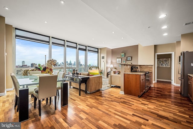 901 N Penn St Unit F2003, Philadelphia, PA 19123 - kitchen featuring stainless steel appliances, wood finished floors, open floor plan, a wall of windows, and light stone countertops