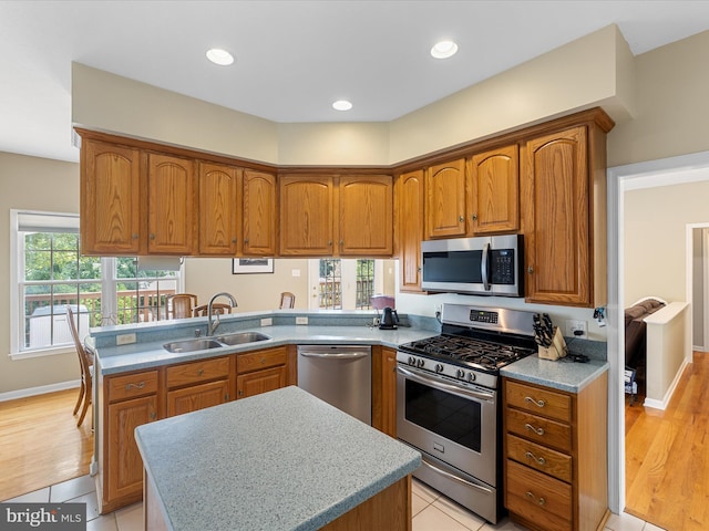 106 Barb Ct, Stephens City, VA 22655 - kitchen featuring appliances with stainless steel finishes, brown cabinets, a peninsula, a kitchen island, and recessed lighting