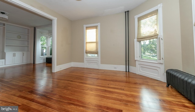 28 Bowen Ave, Woodstown, NJ 08098 - empty room with radiator, plenty of natural light, and hardwood / wood-style floors