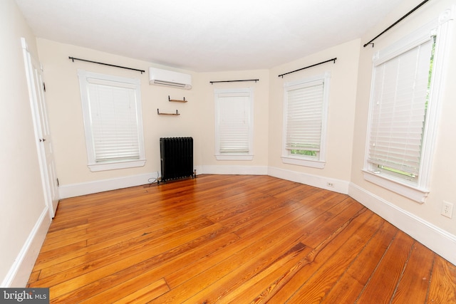 28 Bowen Ave, Woodstown, NJ 08098 - unfurnished living room with radiator heating unit, a wall unit AC, light wood finished floors, and baseboards