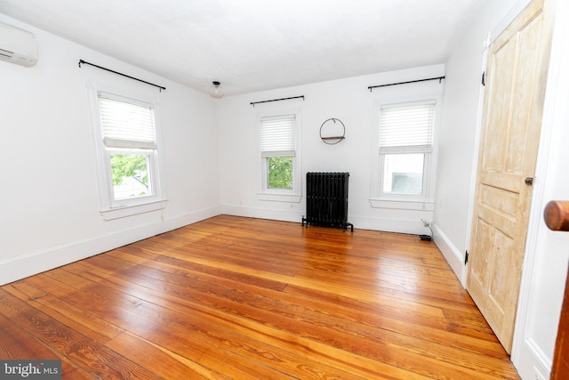 28 Bowen Ave, Woodstown, NJ 08098 - unfurnished living room with radiator, a wall mounted AC, light wood-style flooring, and healthy amount of natural light