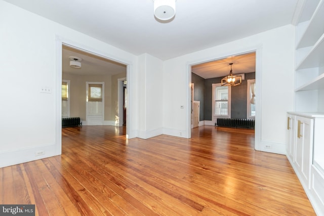 28 Bowen Ave, Woodstown, NJ 08098 - unfurnished room with radiator heating unit, a chandelier, light wood finished floors, and baseboards