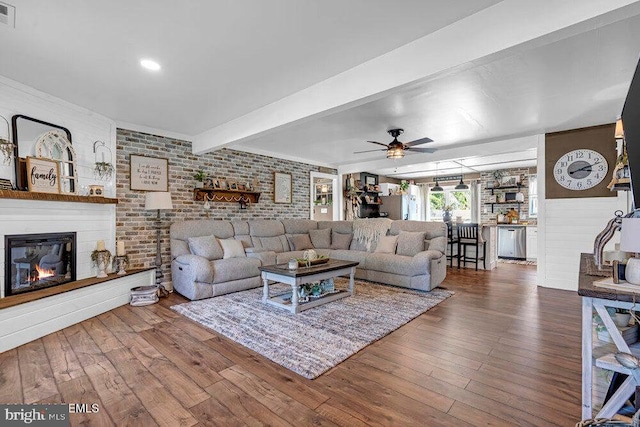 111 Lawrence Dr, Lanoka Harbor, NJ 08734 - living room featuring wood finished floors, a glass covered fireplace, a ceiling fan, beamed ceiling, and brick wall