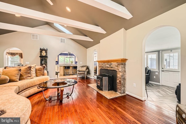 3528 Cohasset Ave, Annapolis, MD 21403 - living room featuring arched walkways, a wood stove, plenty of natural light, hardwood / wood-style floors, and beam ceiling