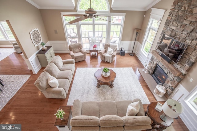 228 Chandler Way, Perkasie, PA 18944 - living room with a stone fireplace, a ceiling fan, wood finished floors, crown molding, and a decorative wall