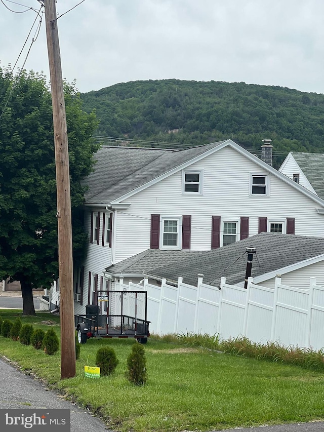 718 W Pine St, Shamokin, PA 17872 - view of home's exterior with roof with shingles, a chimney, and a wooded view