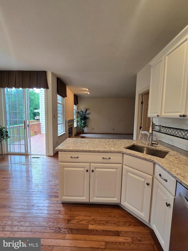 721 Kincaid Mills Ln, Wallingford, PA 19086 - kitchen featuring white cabinetry, hardwood / wood-style floors, dishwasher, backsplash, and a peninsula