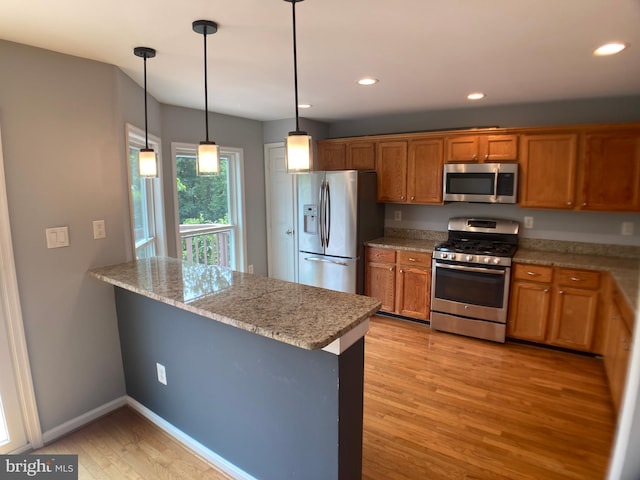 8726 Wadebrook Ter, Springfield, VA 22153 - kitchen featuring appliances with stainless steel finishes, light wood-type flooring, brown cabinetry, a peninsula, and recessed lighting