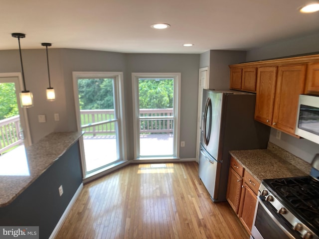 8726 Wadebrook Ter, Springfield, VA 22153 - kitchen with appliances with stainless steel finishes, brown cabinets, light wood finished floors, light stone counters, and recessed lighting