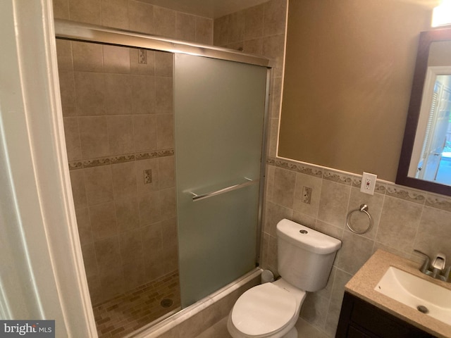 8726 Wadebrook Ter, Springfield, VA 22153 - full bathroom with vanity, a stall shower, toilet, tile walls, and a wainscoted wall