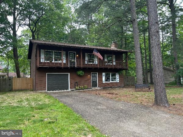 21605 Columbia St, Lexington Park, MD 20653 - view of front facade with driveway, a balcony, a chimney, and a garage
