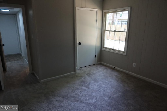 21605 Columbia St, Lexington Park, MD 20653 - unfurnished bedroom featuring carpet floors, multiple windows, baseboards, wood walls, and a closet