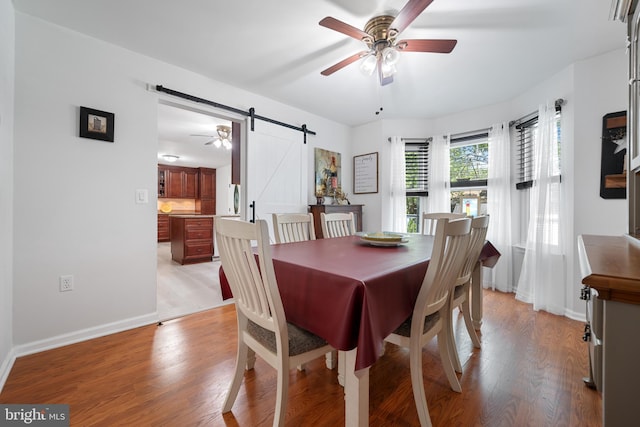 470 N Nautilus Dr, Manahawkin, NJ 08050 - dining area with a barn door, ceiling fan, and light wood-type flooring