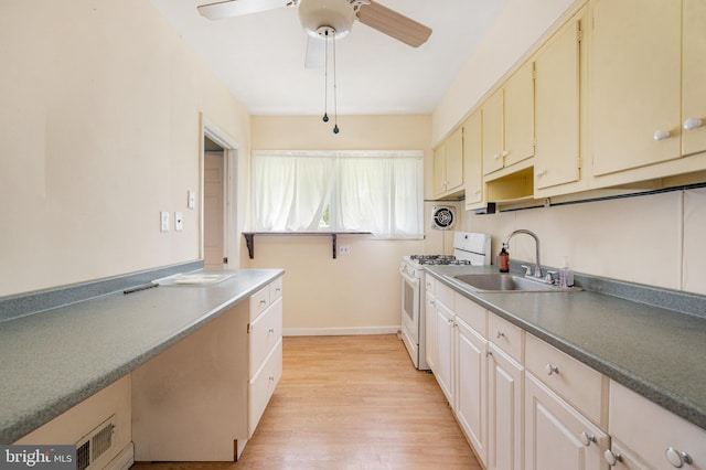2000 Longview Ct, Baltimore, MD 21237 - kitchen with white range with gas stovetop, light wood finished floors, a ceiling fan, and cream cabinetry