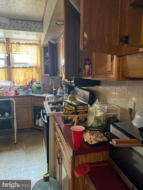 4146 Robbins Ave, Philadelphia, PA 19135 - kitchen featuring stove, brown cabinetry, and a sink
