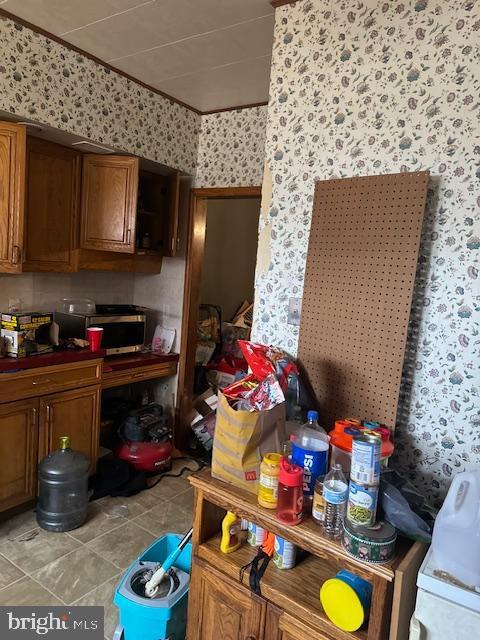 4146 Robbins Ave, Philadelphia, PA 19135 - kitchen with wallpapered walls, brown cabinets, and light tile patterned floors