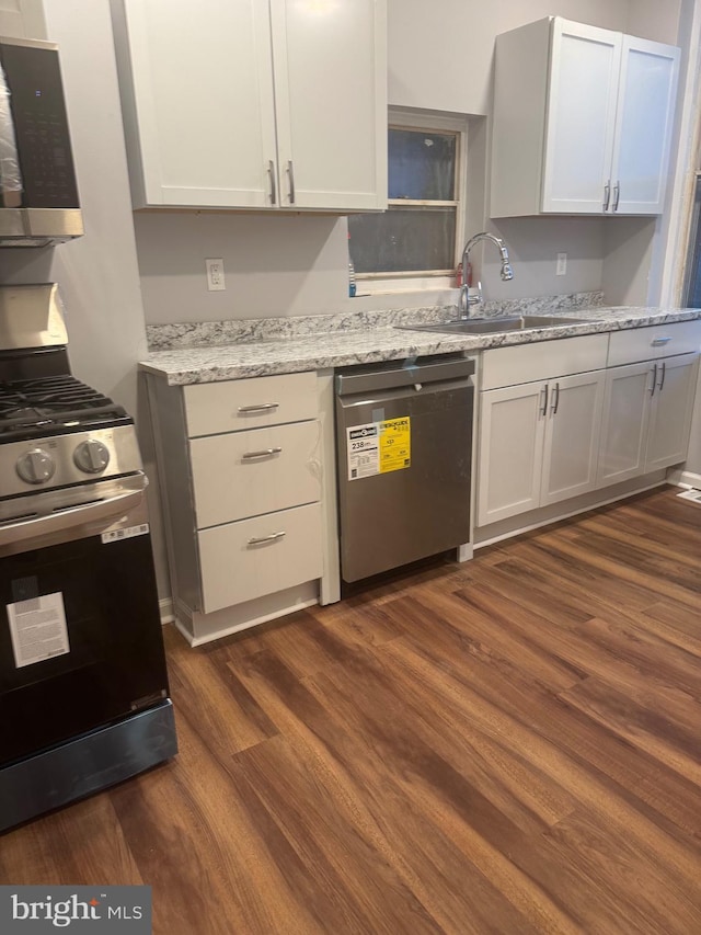 2732 Riggs Ave, Baltimore, MD 21216 - kitchen with appliances with stainless steel finishes, dark wood-style flooring, and light stone counters