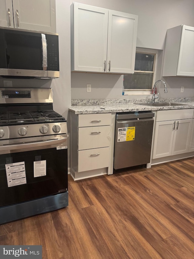 2732 Riggs Ave, Baltimore, MD 21216 - kitchen featuring stainless steel appliances, dark wood-style flooring, and light stone countertops