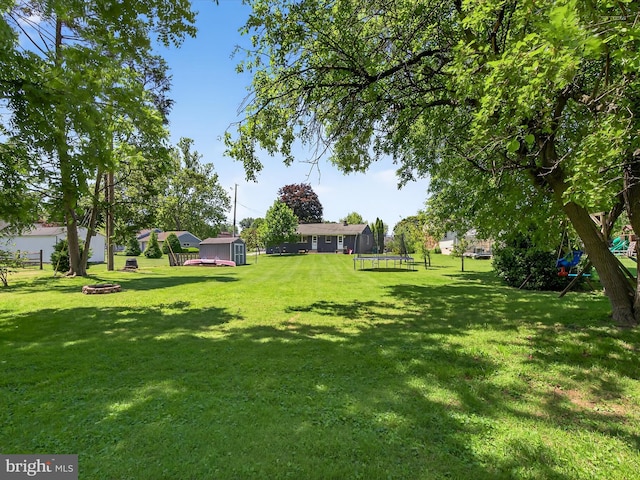303 Stevens Ave, Reading, PA 19608 - view of green lawn featuring a trampoline and a fire pit