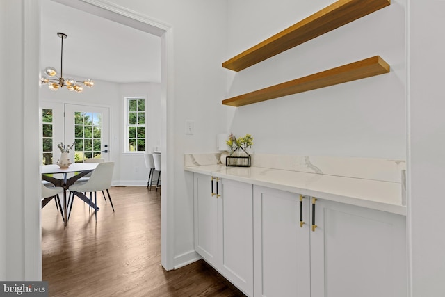 5204 Muirfield Dr, Ijamsville, MD 21754 - kitchen featuring open shelves, dark wood-type flooring, a chandelier, baseboards, and light stone counters