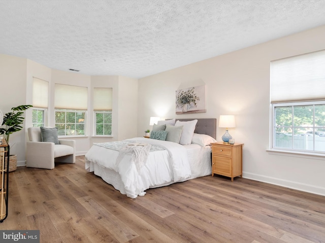 621 Admiral Dr Unit 207, Annapolis, MD 21401 - bedroom with wood finished floors, a textured ceiling, and baseboards