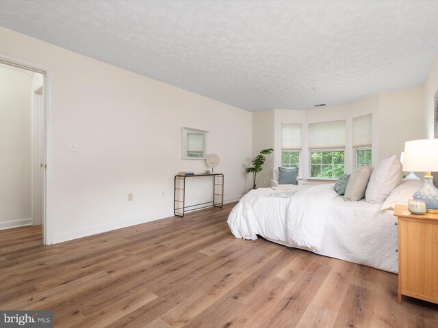 621 Admiral Dr Unit 207, Annapolis, MD 21401 - bedroom with wood finished floors and a textured ceiling