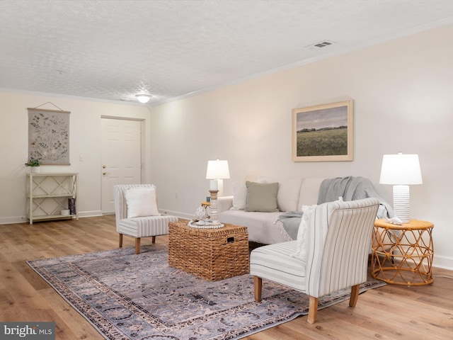 621 Admiral Dr Unit 207, Annapolis, MD 21401 - living room with ornamental molding, wood finished floors, baseboards, and a textured ceiling