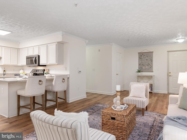 621 Admiral Dr Unit 207, Annapolis, MD 21401 - living area with light wood finished floors, a textured ceiling, baseboards, and crown molding
