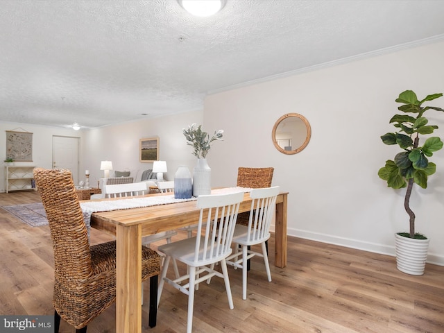 621 Admiral Dr Unit 207, Annapolis, MD 21401 - dining area featuring a textured ceiling, light wood-style flooring, crown molding, and baseboards