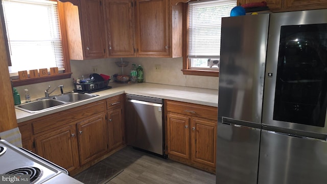 2103 W Trindle Rd, Carlisle, PA 17013 - kitchen featuring appliances with stainless steel finishes, a sink, light countertops, brown cabinetry, and wood finished floors