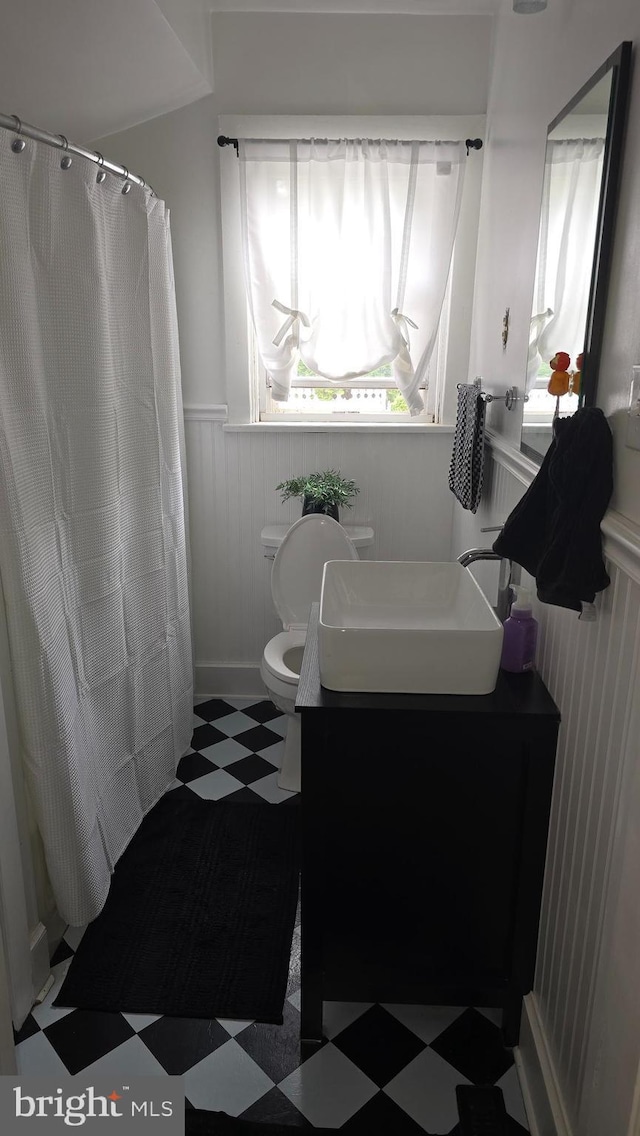 2103 W Trindle Rd, Carlisle, PA 17013 - bathroom featuring tile patterned floors, a wainscoted wall, vanity, toilet, and curtained shower