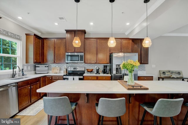 182 Mohegan Dr, Havre De Grace, MD 21078 - kitchen with appliances with stainless steel finishes, a sink, tasteful backsplash, ornamental molding, and decorative light fixtures